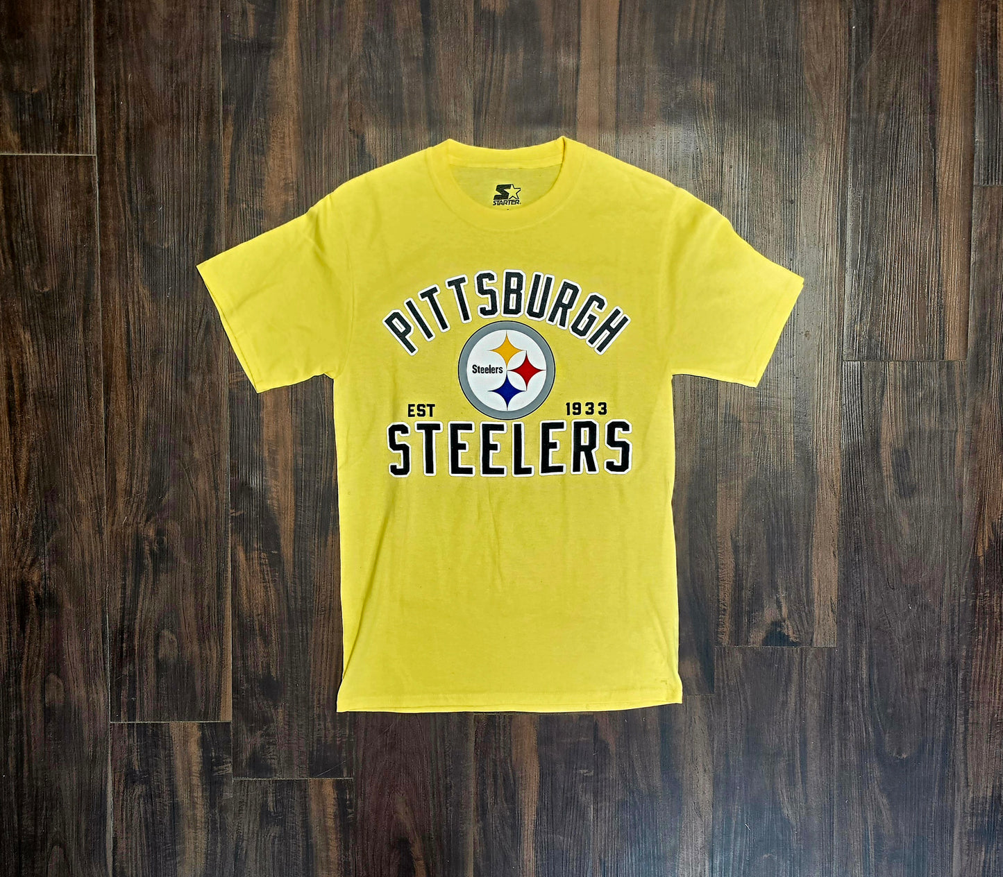 This yellow Starter Pittsburgh Steelers t-shirt features the team's logo and "Est. 1933" text.