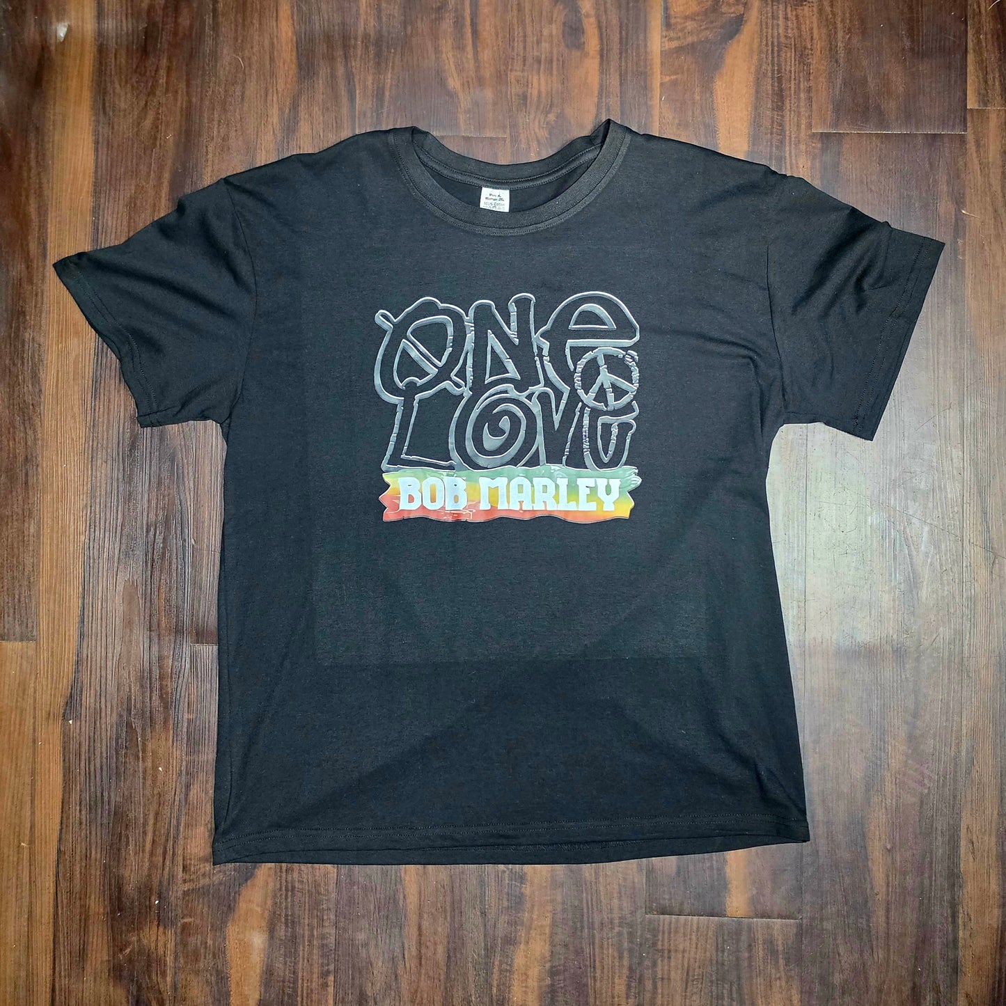 This is a black t-shirt featuring a "One Love" graphic of Bob Marley front and back print size XL Men/ 2XL ladies